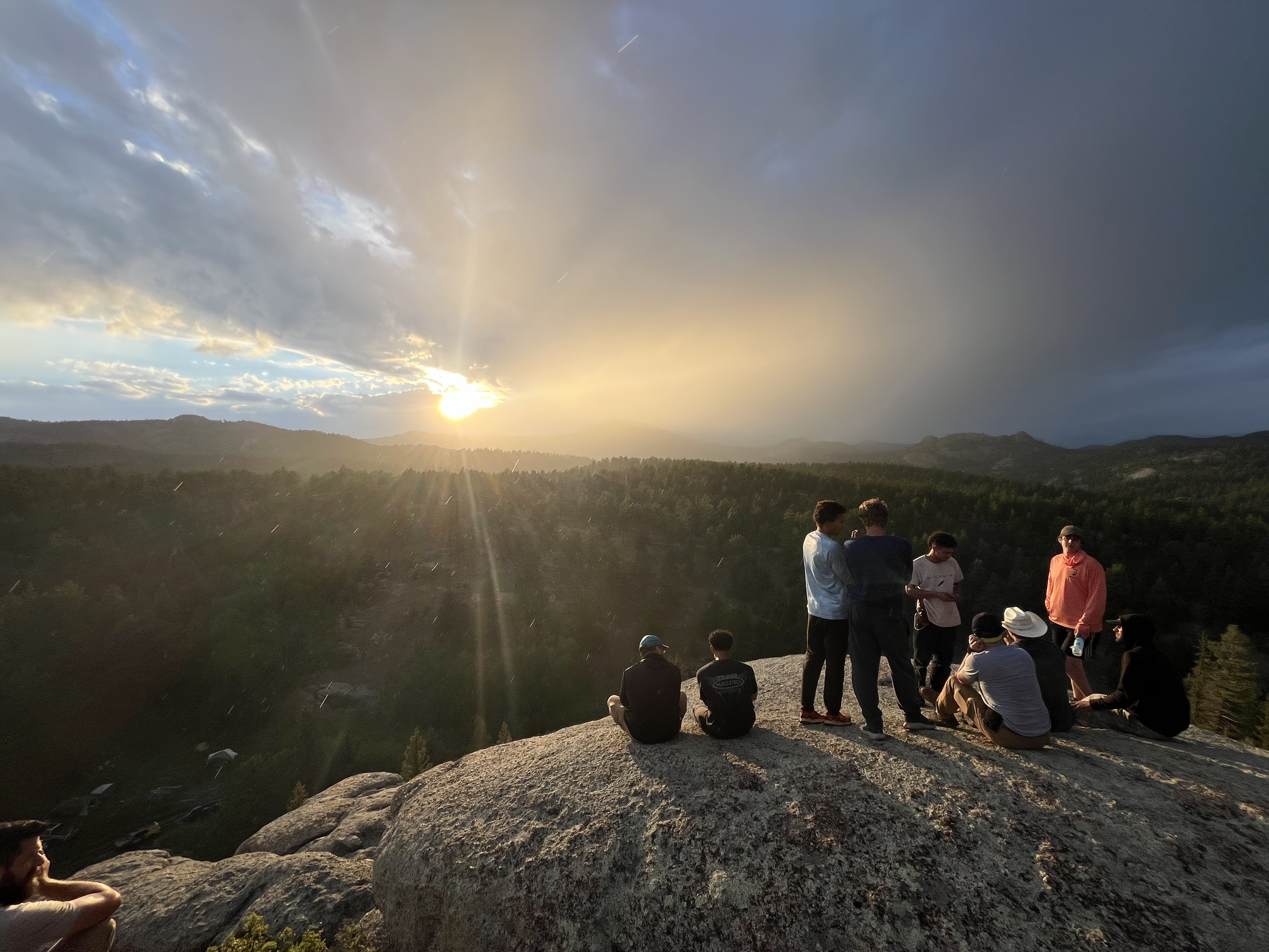 Abide Project young men and mentors together on a mountain summit at sunset
